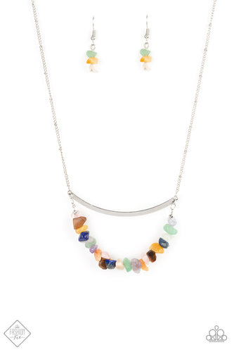 A row of raw cut multicolored rocks are threaded along a dainty wire that bows at the bottom of a curved silver bar, creating an earthy pendant. The colorfully stacked frame swings from the bottom of a lengthened silver satellite chain for a glamorously grounding effect. Features an adjustable clasp closure.  Sold as one individual necklace. Includes one pair of matching earrings.