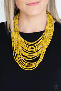 Suspended between two gunmetal fittings, row after row of countless strands of yellow seed beads layer below the collar. Dainty gunmetal seed beads are sprinkled across the strands for a seasonal finish. Features an adjustable clasp closure.  Sold as one individual necklace. Includes one pair of matching earrings.