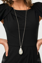 Load image into Gallery viewer, Infused with an elegantly elongated silver chain, a dramatic teardrop gem swings from the bottom of a white rhinestone encrusted silver fitting, creating a hypnotic pendant. Features an adjustable clasp closure.  Sold as one individual necklace. Includes one pair of matching earrings.
