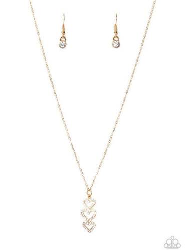 Encrusted in sparkly white rhinestones, a trio of golden heart frames delicately stack into a charming pendant that swings from a dainty gold chain below the collar for a flirty finish. Features an adjustable clasp closure.