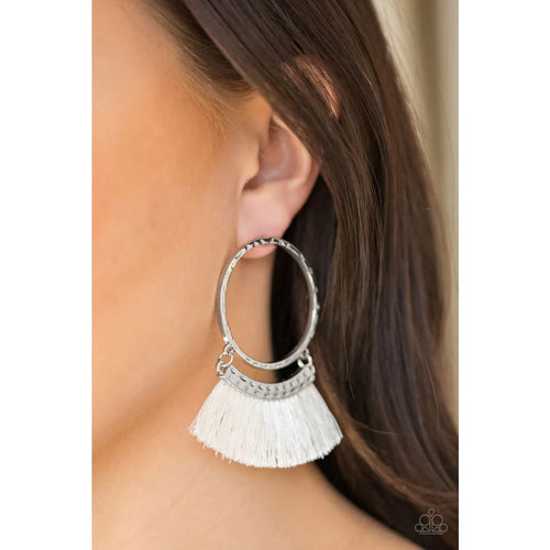 Swinging from the bottom of a hammered silver hoop, shiny white thread flares from a hammered silver frame for a tasseled look. Earring attaches to a standard post fitting. Sold as one pair of post earrings.