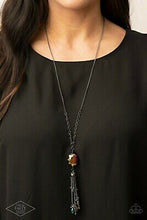 Load image into Gallery viewer, Featuring an oil spill finish, a faceted oil spill gem attaches to the bottom of a lengthened gunmetal chain featuring sections of airy chain links. Infused with dainty gunmetal and matching oil spill beads, shimmery gunmetal chains stream from the bottom of a hematite dotted cap, creating an edgy tassel. Features an adjustable clasp closure.  Sold as one individual necklace. Includes one pair of matching earrings.
