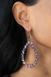 Featuring pronged gunmetal frames, a glittery collection of emerald cut oil spill rhinestones haphazardly stacks into an edgy teardrop for a gritty glamorous look. Earring attaches to a standard fishhook fitting.  Sold as one pair of earrings.