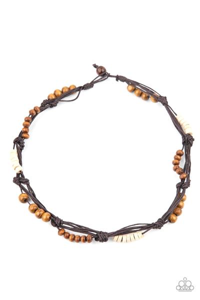 Featuring round and disc shapes, mismatched sections of brown and white wooden beads are knotted along strands of brown cording that loop around the neck for an island inspired look. Features a button loop closure.